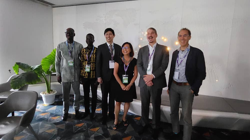A group of people at the African Carbon Market conference, standing and smiling at the camera